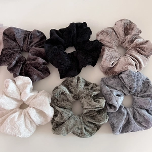 Detail showing 6 colors of soft velvet scrunchies with elegant glossy fabric texture