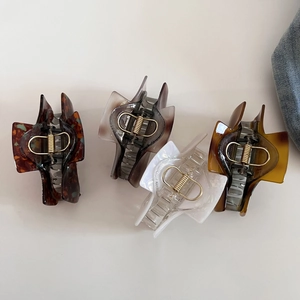 Flat lay of four vintage square hair claws in tortoiseshell and smoky grey styles