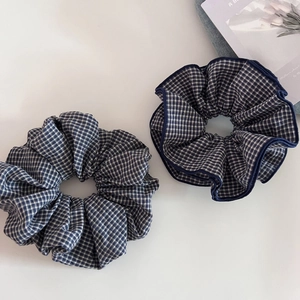 Dettaglio di scrunchies in tessuto a quadretti blu e bianchi in un set di due pezzi