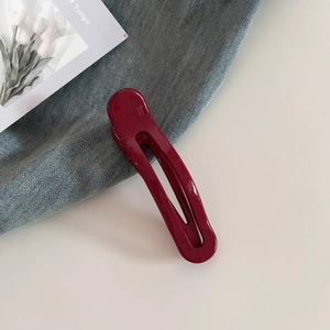 Detail of burgundy acetate hair clip with France Handmade text on denim background