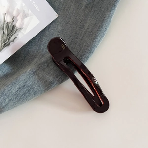 Detailed macro view of dark coffee acetate hair clip with golden France Handmade logo