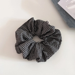 Dettaglio macro dell'elastico per capelli a scacchi bianchi e neri in cotone