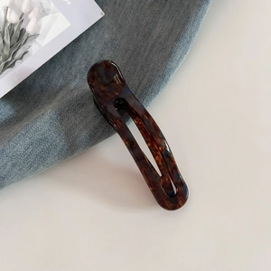 Detailed close-up of amber tortoiseshell hair clip with France Handmade lettering