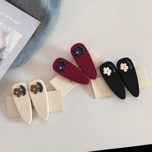 Three pairs of elegant acetate drop hair clips with 3D floral accents on display card