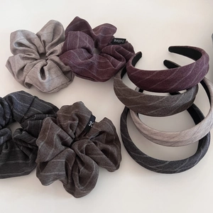 Detail of herringbone fabric scrunchies and headbands in grey, burgundy, and brown