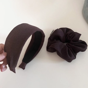 Detail of dark brown wool fabric headband and matching scrunchie with soft matte texture