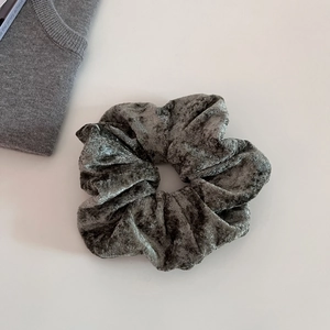 Detail of dark grey velvet scrunchie showing soft fabric texture and elastic pleats