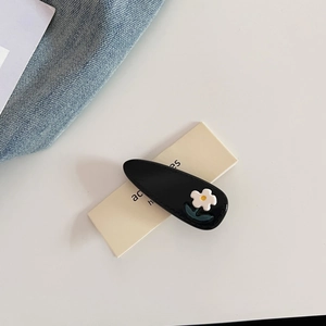 Detail of Korean style floral hair clip with white flower on a yellow card holder