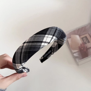 Detail showing the thick sponge headband with tartan pattern and Hand Made woven label