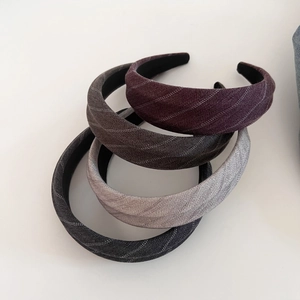 Close-up of four striped fabric headbands in purple, brown, and grey with inner lining