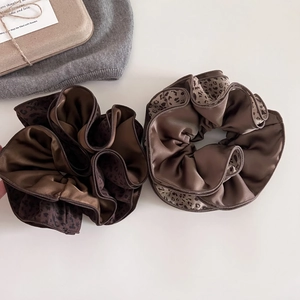 Elegant leopard print satin scrunchies in brown and tan tones with ruffled details