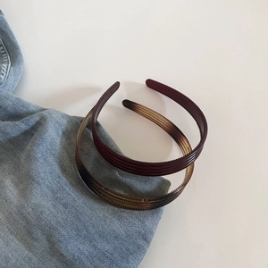 Vue détaillée de serre-têtes texturés fins en ambre et marron avec dents antidérapantes