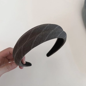 Macro shot of wide dark grey twill fabric headband with subtle textured stripe details