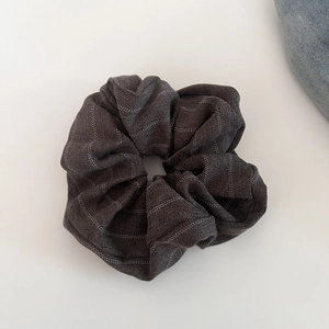 Close-up of vintage grey striped plaid fabric texture on a high-quality hair scrunchie