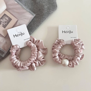 Detail of pink satin scrunchies with white pearl embellishment on elegant card display