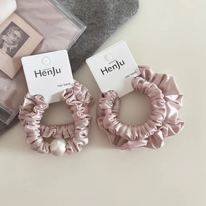 Detail of pink satin hair scrunchies with white pearl on premium display card
