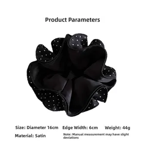 Close-up of black and white polka dot satin oversized scrunchie with layered design