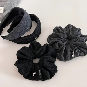 Close-up of wool-textured gray hair scrunchies and headbands with silver bear charms