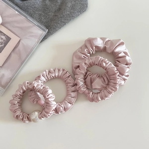 Elegant pink satin hair scrunchies set with faux pearl detail on soft fabric