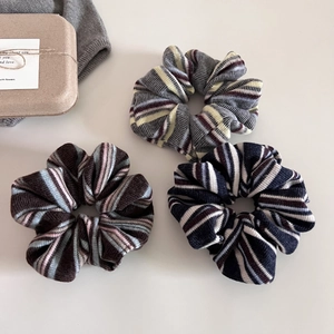 Detailed macro view of soft knit striped scrunchies in vintage preppy style colors