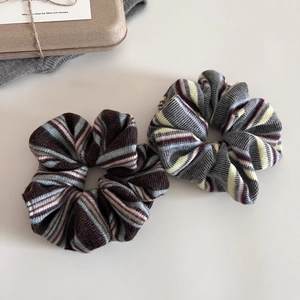 Close-up of soft knitted striped scrunchies in coffee and grey tones with texture