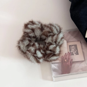 Close-up of plush brown and beige faux fur scrunchie with soft autumn texture