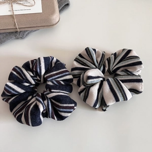 Macro detail of soft striped knit scrunchies in retro preppy style with ribbed texture