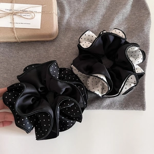 Detail of black and white polka dot satin scrunchies with four-layer lock edge design