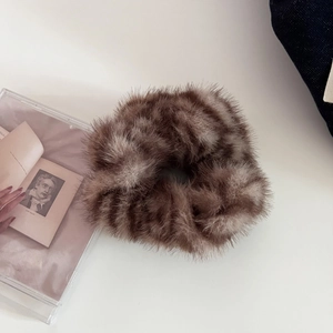 Detail of soft brown faux fur scrunchie with plush texture for elegant hairstyles