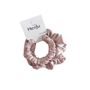 Elegant light pink satin scrunchie with elastic hair band on white packaging card