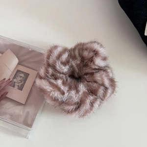 Detailed close-up of a soft pink brown plush scrunchie with fluffy faux fur texture