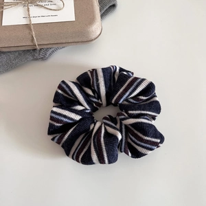 Detail of soft knit striped scrunchie in retro navy blue and red collegiate style