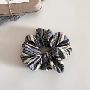 Detailed close-up of retro striped knit scrunchie with soft texture and rich multi-colors