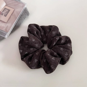 Detail of dark brown floral knit scrunchie showing soft texture and pleated design
