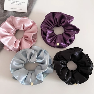 Vue détaillée de quatre chouchous en satin haut de gamme en rose, violet, bleu et noir