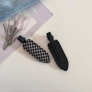 Close-up of black and white plaid fabric hair clips with black metal back clip detail