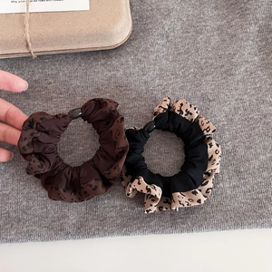 Detail of leopard print scrunchies with stylish resin buckles and ruffled fabric edges