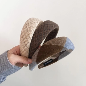 Detail of three thick plaid wool headbands with handmade labels for winter fashion