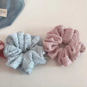 Detail of light blue and pink hollow lace scrunchies with soft crochet texture