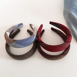Detailed view of handmade plaid wool headbands with vintage fabric texture and woven labels