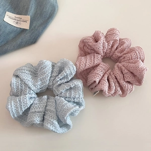 Close-up of sweet lace scrunchies in light blue and pink with hollow floral texture