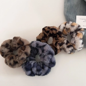 Detailed set of four plush leopard print scrunchies in assorted animal pattern colors