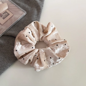 Dettaglio dell'elastico in velluto a pois rosa tenue con pieghe di alta qualità