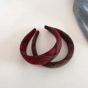 Detail view of plaid wool and brown plush headbands with handmade interior label