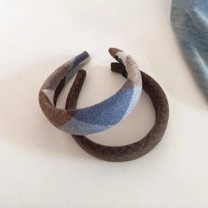 Close-up of thick plaid and solid brown wool hairbands with soft texture for winter