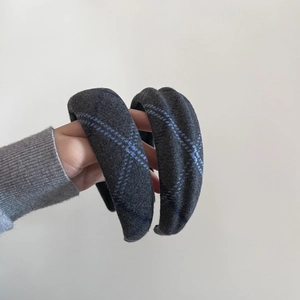 Detailed texture of thick grey plaid woolen headband with padded high top design