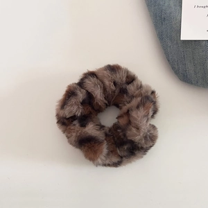 Close-up of fluffy leopard print plush scrunchie with soft faux fur texture for hair
