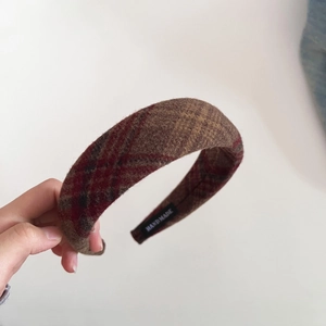 Detail of handmade woven plaid wool headband showing the fabric texture and inner tag