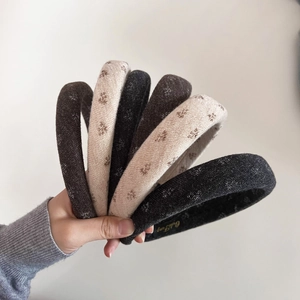 Detailed shot of knitted floral sponge headbands in brown, beige, and grey colors
