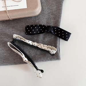 Three-pack of retro polka dot bow banana hair clips in classic black and white style